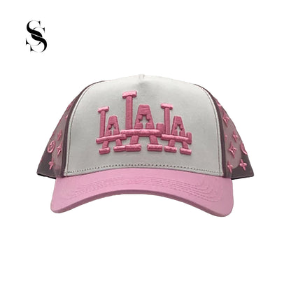 Gorra Rude Awakings LALALA en blanco y rosa, marca Second Shot, con detalles bordados en rosa y diseño llamativo y moderno.