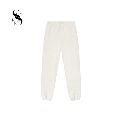 Pantalón tipo jogger Fear of God Essentials en color blanco hueso light oatmeal con cordones ajustables largos, parche frontal de goma y puños elásticos en los tobillos