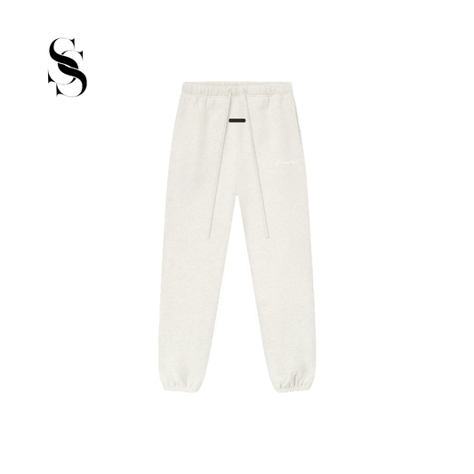 Pantalón tipo jogger Fear of God Essentials en color blanco hueso light oatmeal con cordones ajustables largos, parche frontal de goma y puños elásticos en los tobillos